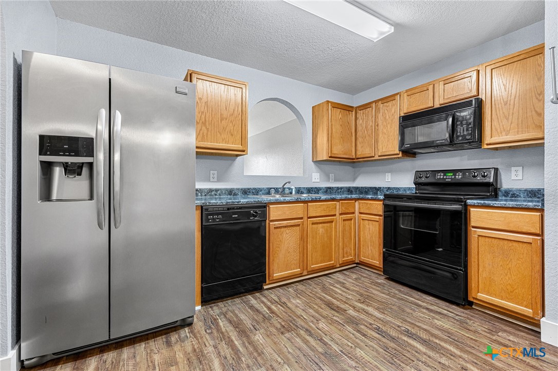 3208 Viewcrest Drive Killeen, TX 76549 - Photo 4 of 15 a kitchen with stainless steel appliances granite countertop a refrigerator a sink dishwasher a stove and white countertops with wooden floor