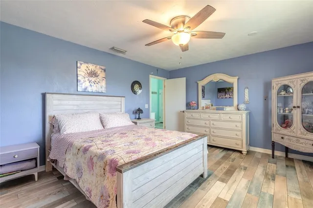 a bedroom with a large bed a chandelier and dresser