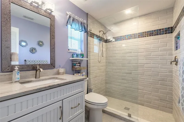 a bathroom with a granite countertop sink toilet and shower