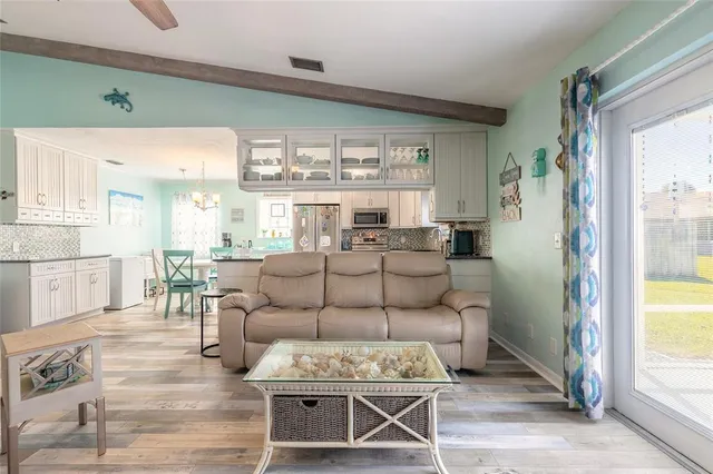 a living room with furniture a large window and a dining table