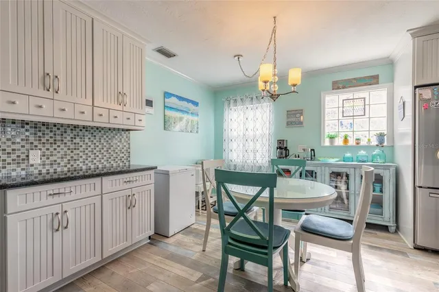 a kitchen with granite countertop white cabinets chairs and white appliances