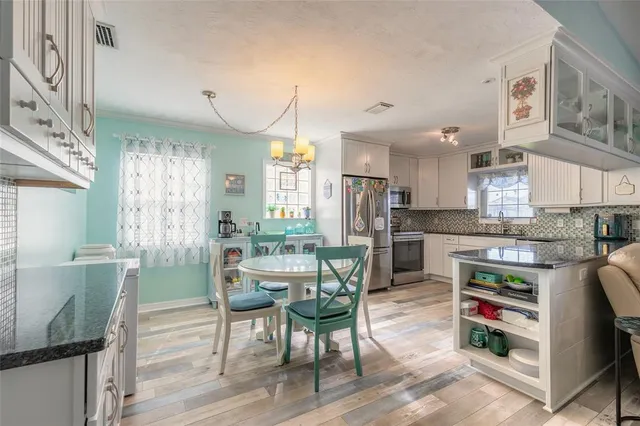 a kitchen with furniture wooden floor and stainless steel appliances