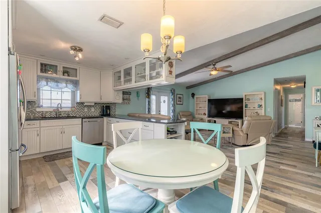a kitchen with a dining table chairs a sink and cabinets