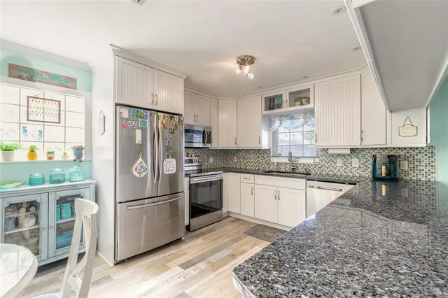 a kitchen with stainless steel appliances granite countertop a refrigerator sink and cabinets
