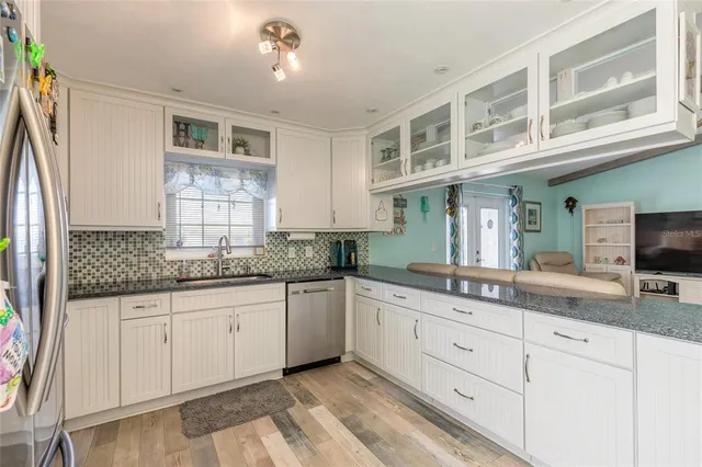 a kitchen with granite countertop a sink and cabinets