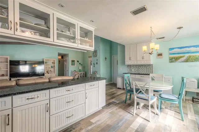 a kitchen with cabinets and chairs