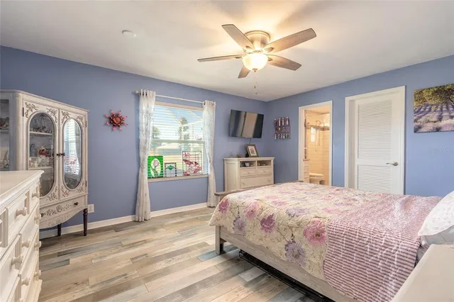a bedroom with a large bed a chandelier and dresser