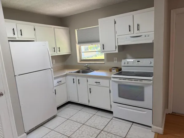 a kitchen with cabinets stainless steel appliances and a sink