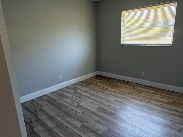 a view of a room with wooden floor and windows