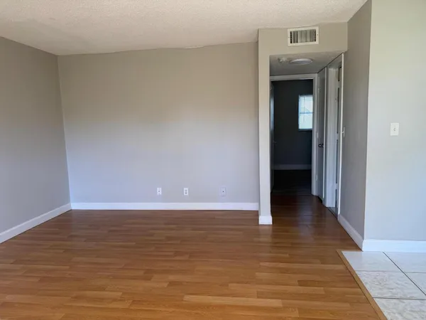 a view of an empty room and wooden floor