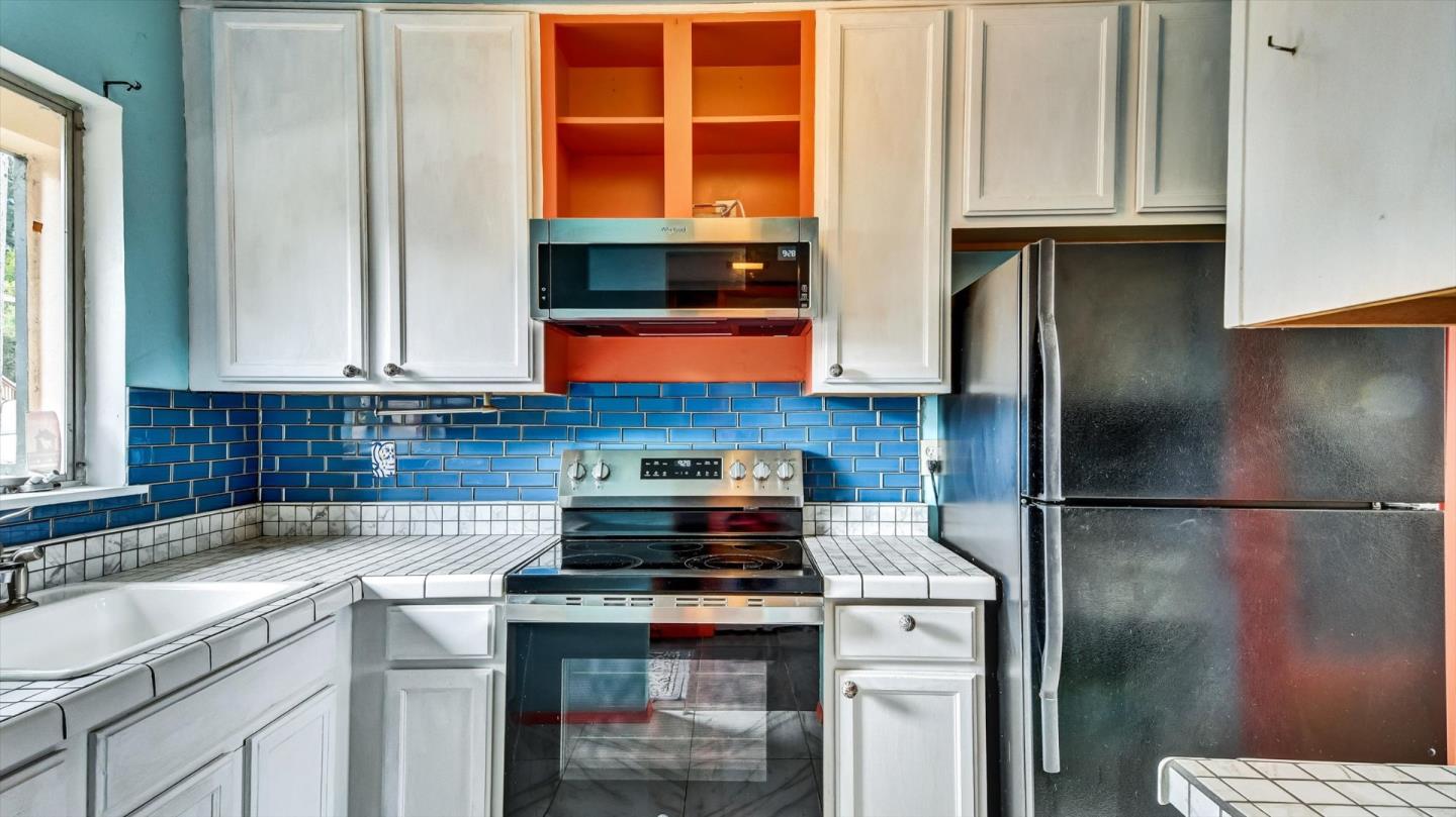 1201 Terra Nova Boulevard Pacifica, CA 94044 - Photo 13 of 28 a kitchen with stainless steel appliances granite countertop a stove a refrigerator and a sink
