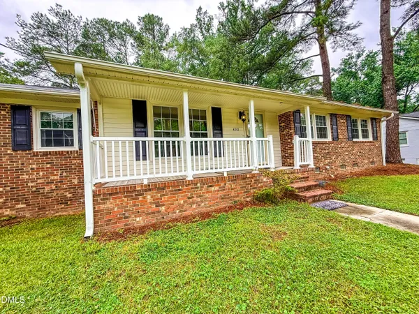 a view of a house with a yard and sitting area