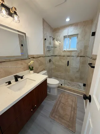 a bathroom with a double vanity sink toilet mirror and bathtub