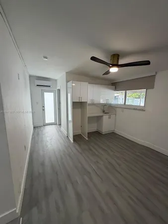 a view of a livingroom with wooden floor and a ceiling fan