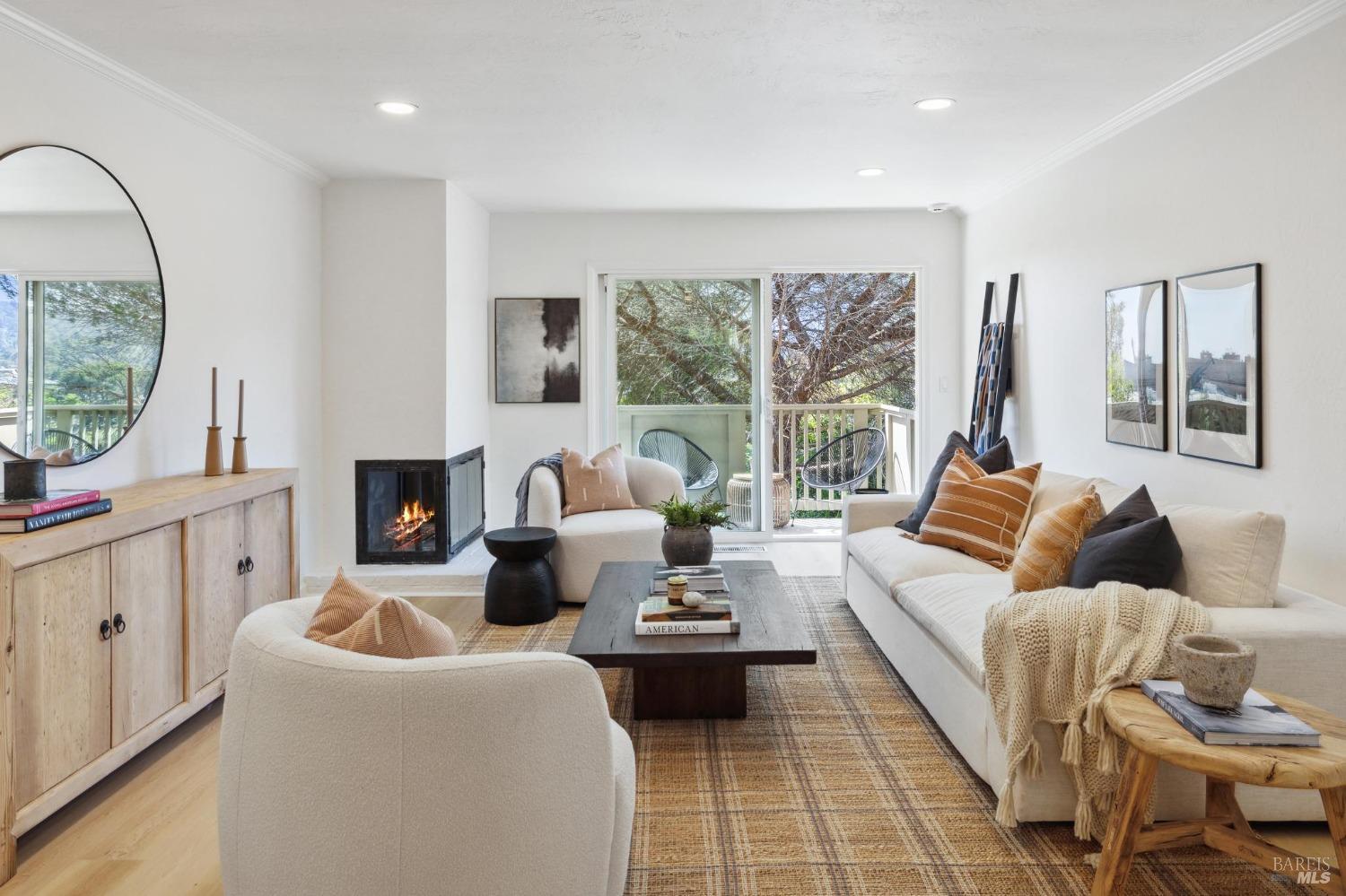 a living room with furniture fireplace and a large window
