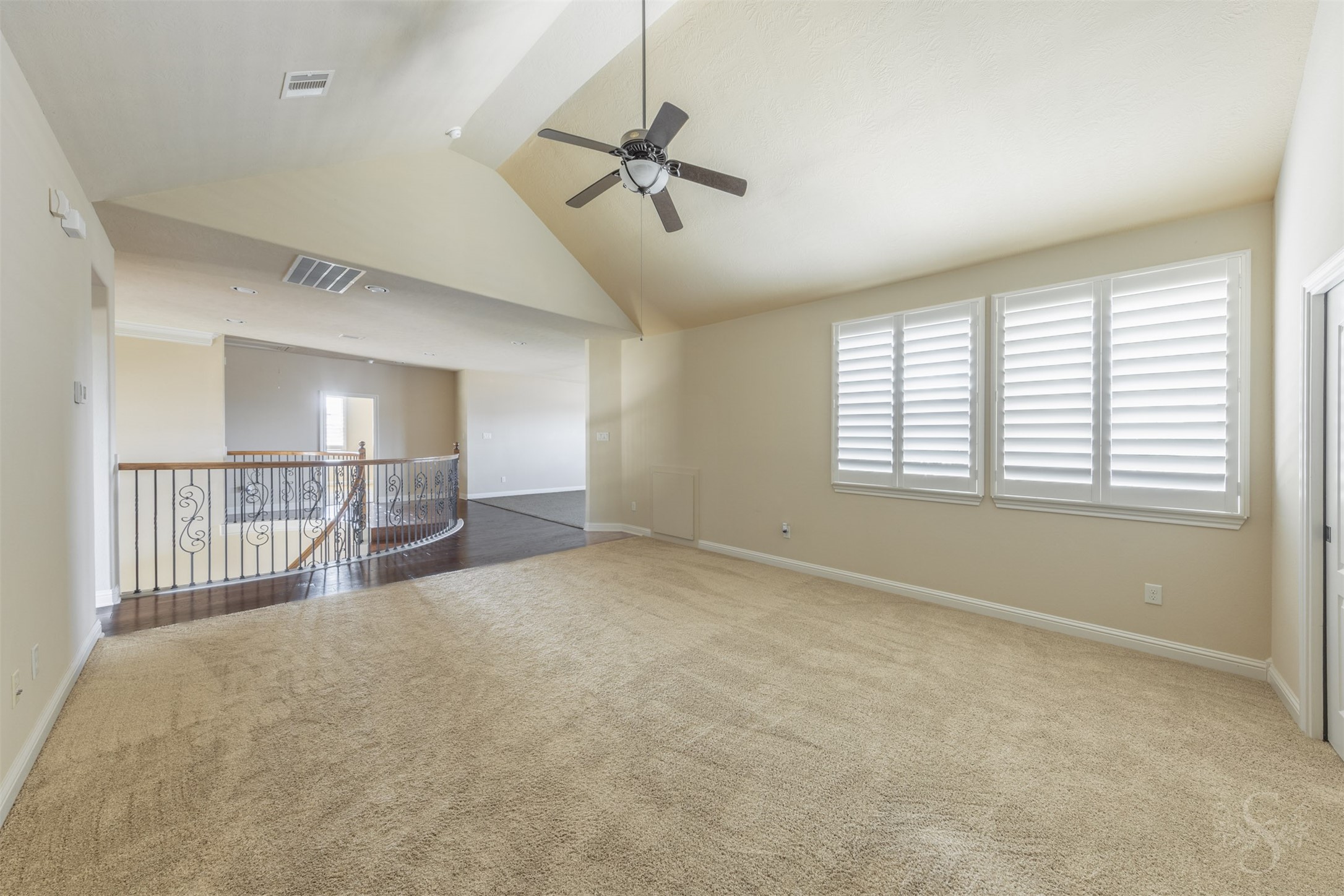 5803 Mustang Ridge Lane Fulshear, TX 77441 - Photo 28 of 48 Expansive upstairs game room features soaring ceilings, rich wood flooring at the entry and windows with plantation shutters that bring in soft natural light. The open layout offers exceptional flexibility for entertaining, lounging or creating multiple activity spaces.