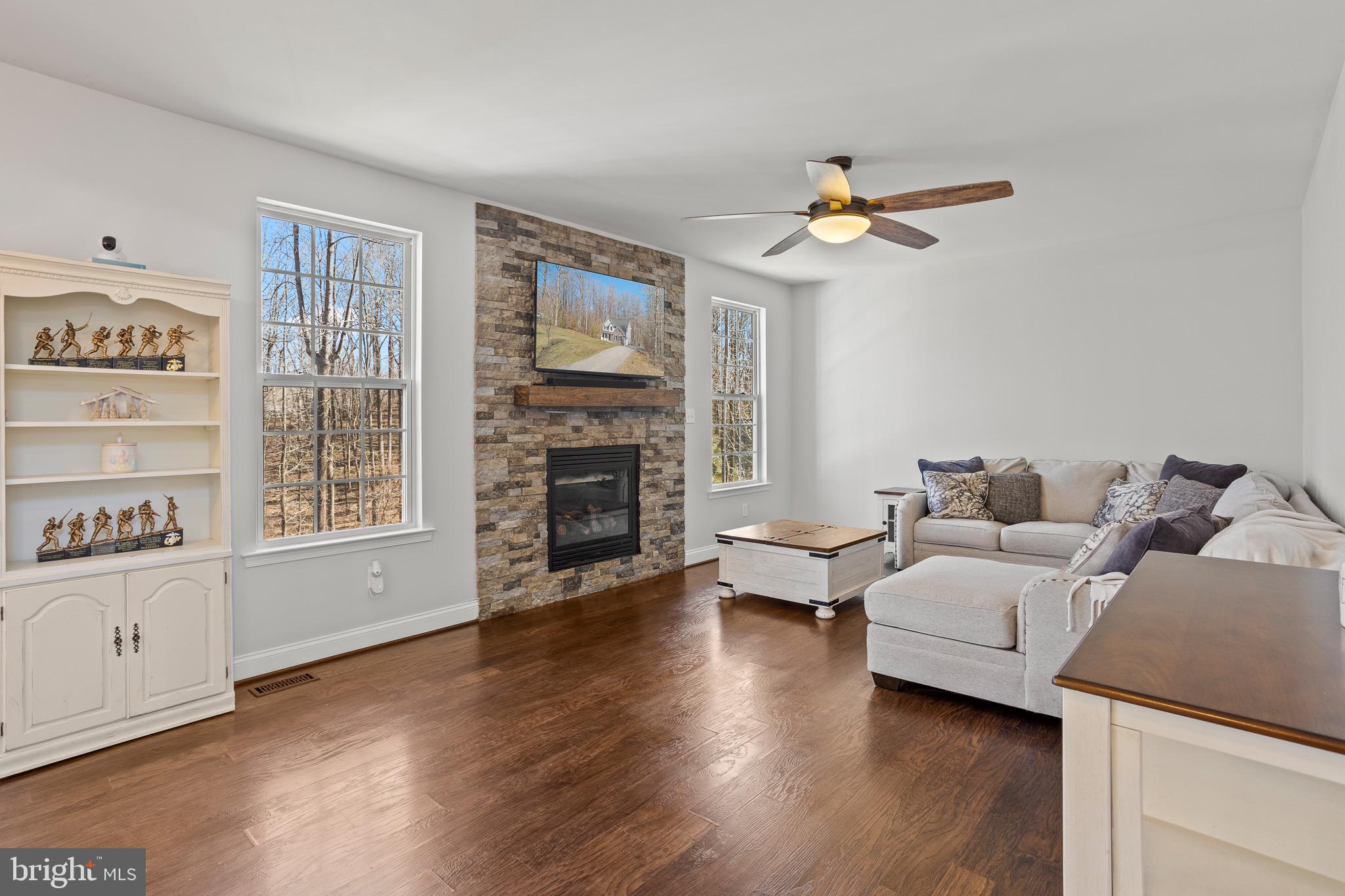4335 Pleasant Court Huntingtown, MD 20639 - Photo 12 of 46 a living room with furniture a fireplace and a flat screen tv