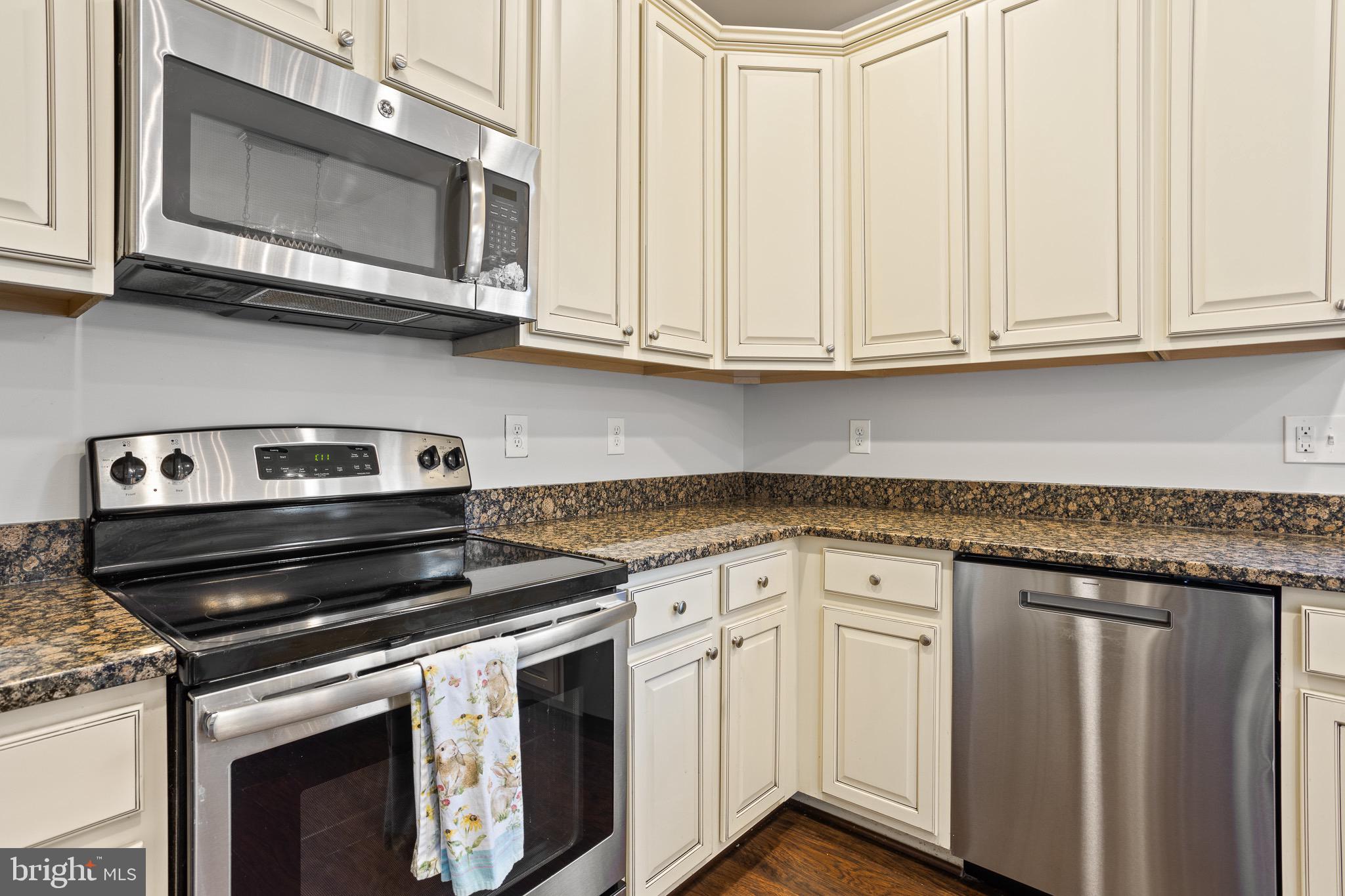 4335 Pleasant Court Huntingtown, MD 20639 - Photo 7 of 46 a kitchen with granite countertop white cabinets and a stove top oven