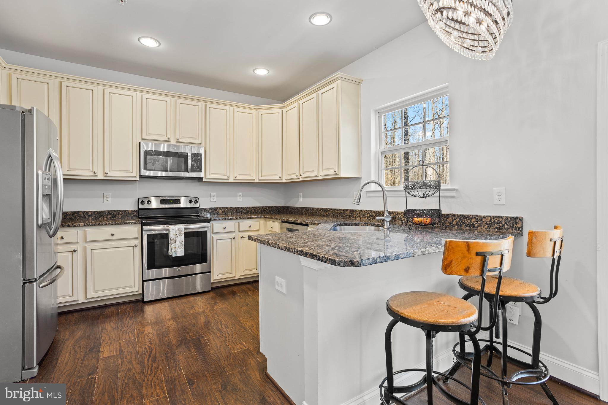 4335 Pleasant Court Huntingtown, MD 20639 - Photo 9 of 46 a kitchen with stainless steel appliances granite countertop a stove a sink dishwasher and a refrigerator with wooden floor