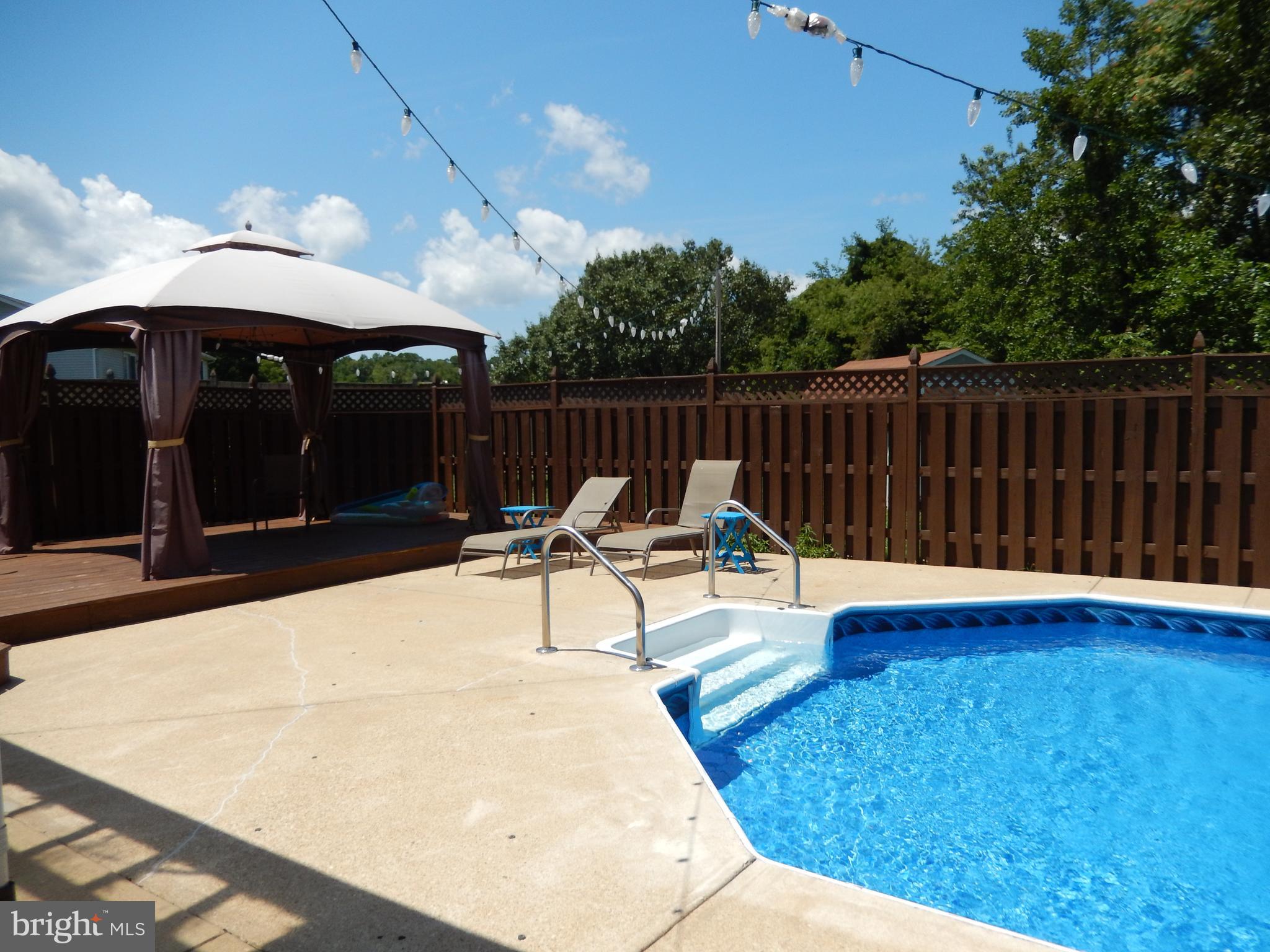 11905 Mill Bridge Road Lusby, MD 20657 - Photo 45 of 59 a view of a patio with a table and chairs