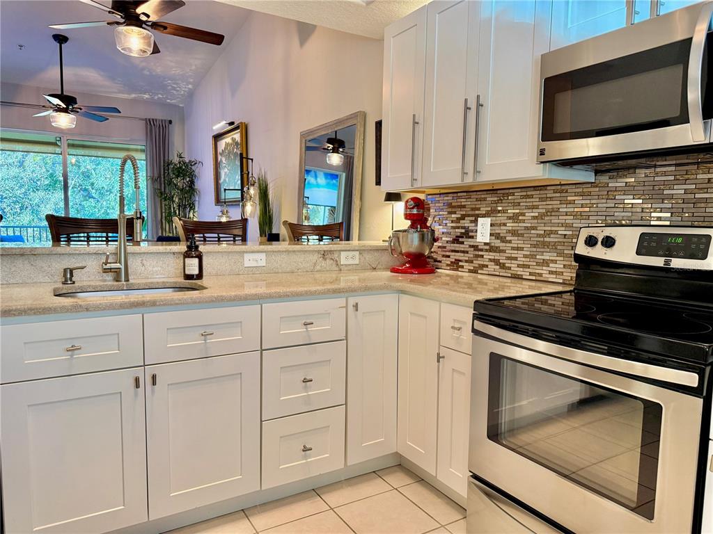 100 San Juan Drive, Unit A203 Palm Coast, FL 32137 - Photo 19 of 59 a kitchen with white cabinets and appliances