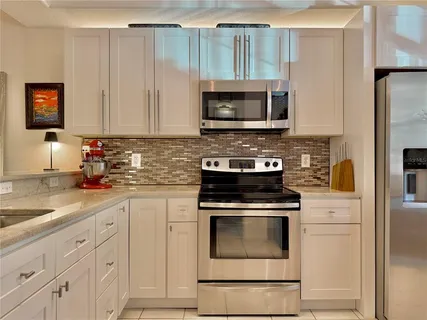 a kitchen with white cabinets and stainless steel appliances