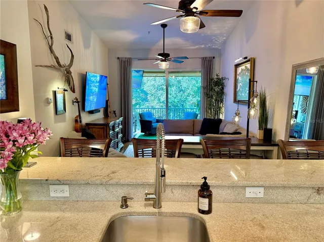 a living room with kitchen island granite countertop furniture and a chandelier