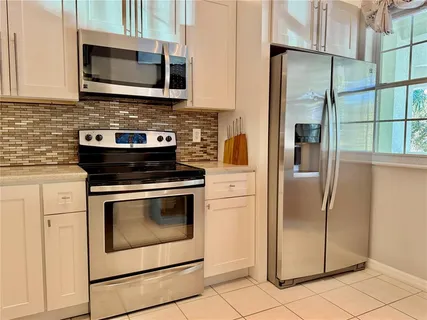 a kitchen with stainless steel appliances granite countertop a stove microwave and refrigerator