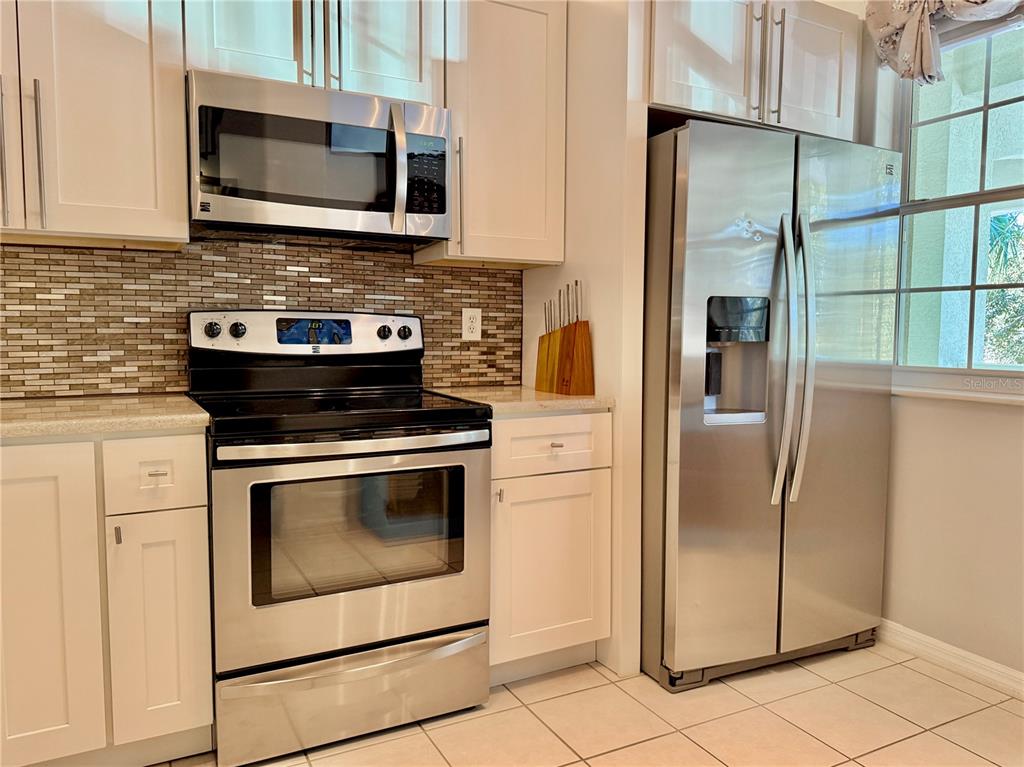100 San Juan Drive, Unit A203 Palm Coast, FL 32137 - Photo 24 of 59 a kitchen with stainless steel appliances granite countertop a stove microwave and refrigerator
