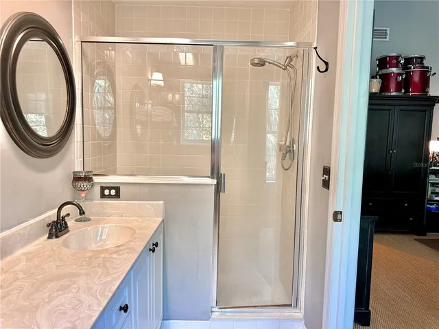 a bathroom with a granite countertop sink a mirror and a shower