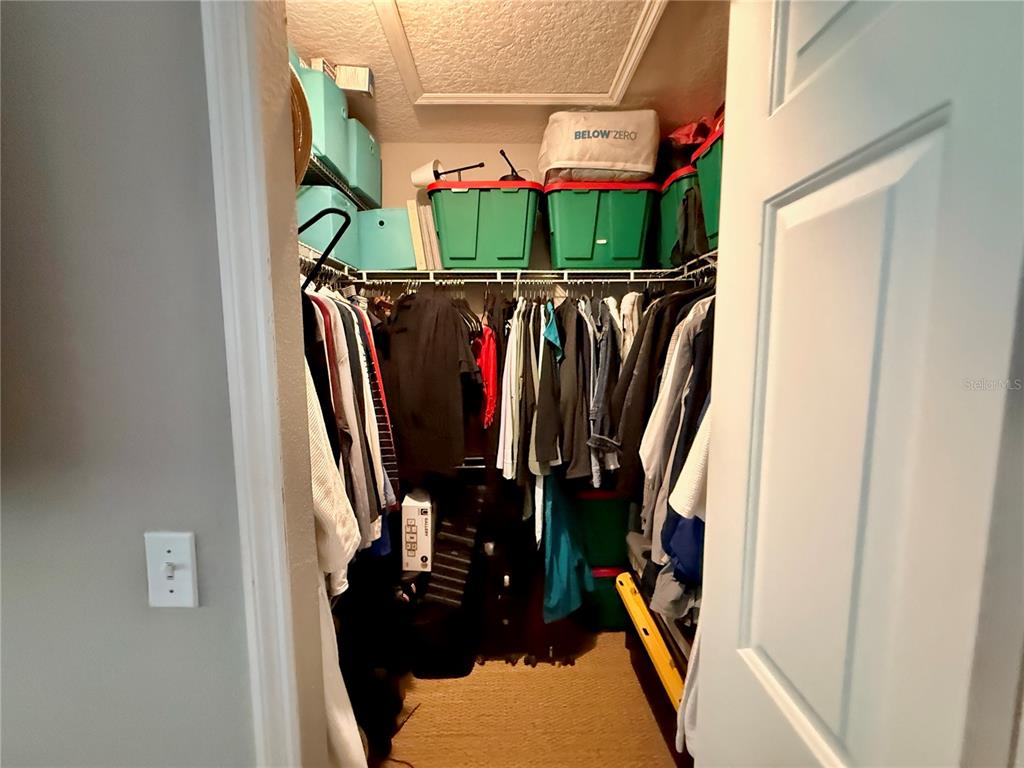 100 San Juan Drive, Unit A203 Palm Coast, FL 32137 - Photo 38 of 59 a view of walk in closet with clothes and shoes