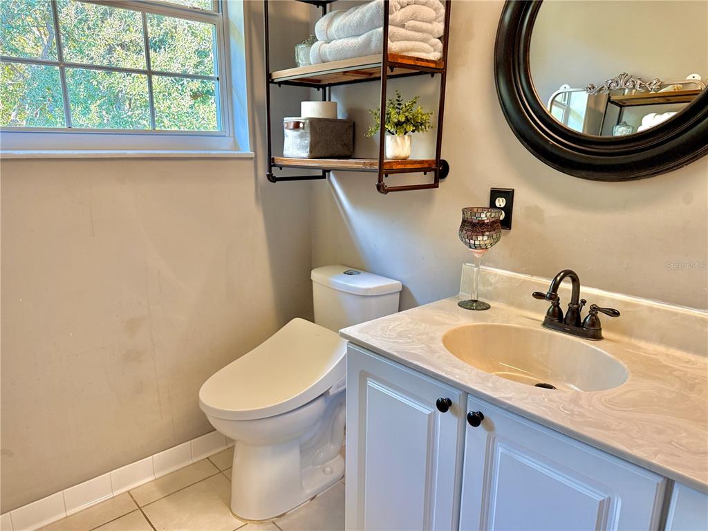 100 San Juan Drive, Unit A203 Palm Coast, FL 32137 - Photo 40 of 59 a bathroom with a toilet sink and mirror