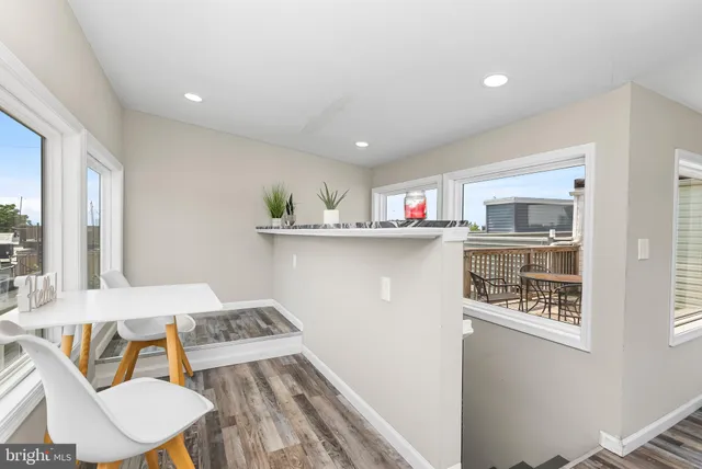 a kitchen that has a sink a microwave oven a stove and white cabinets with wooden floor