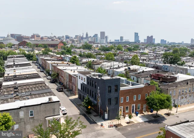 an aerial view of a house with yard garage and a city view