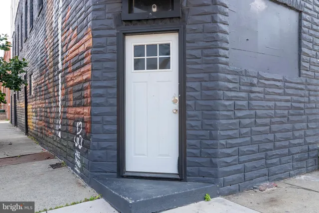 a view of a brick house with many windows and a tree