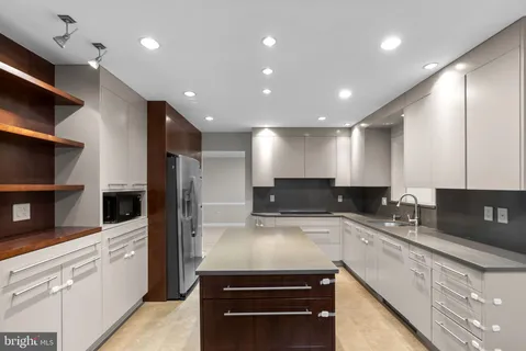 a kitchen with kitchen island a sink stainless steel appliances and cabinets
