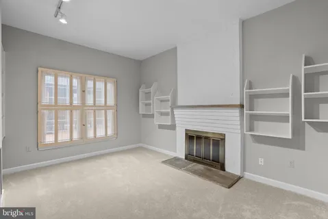 an empty room with a chandelier fan and a window
