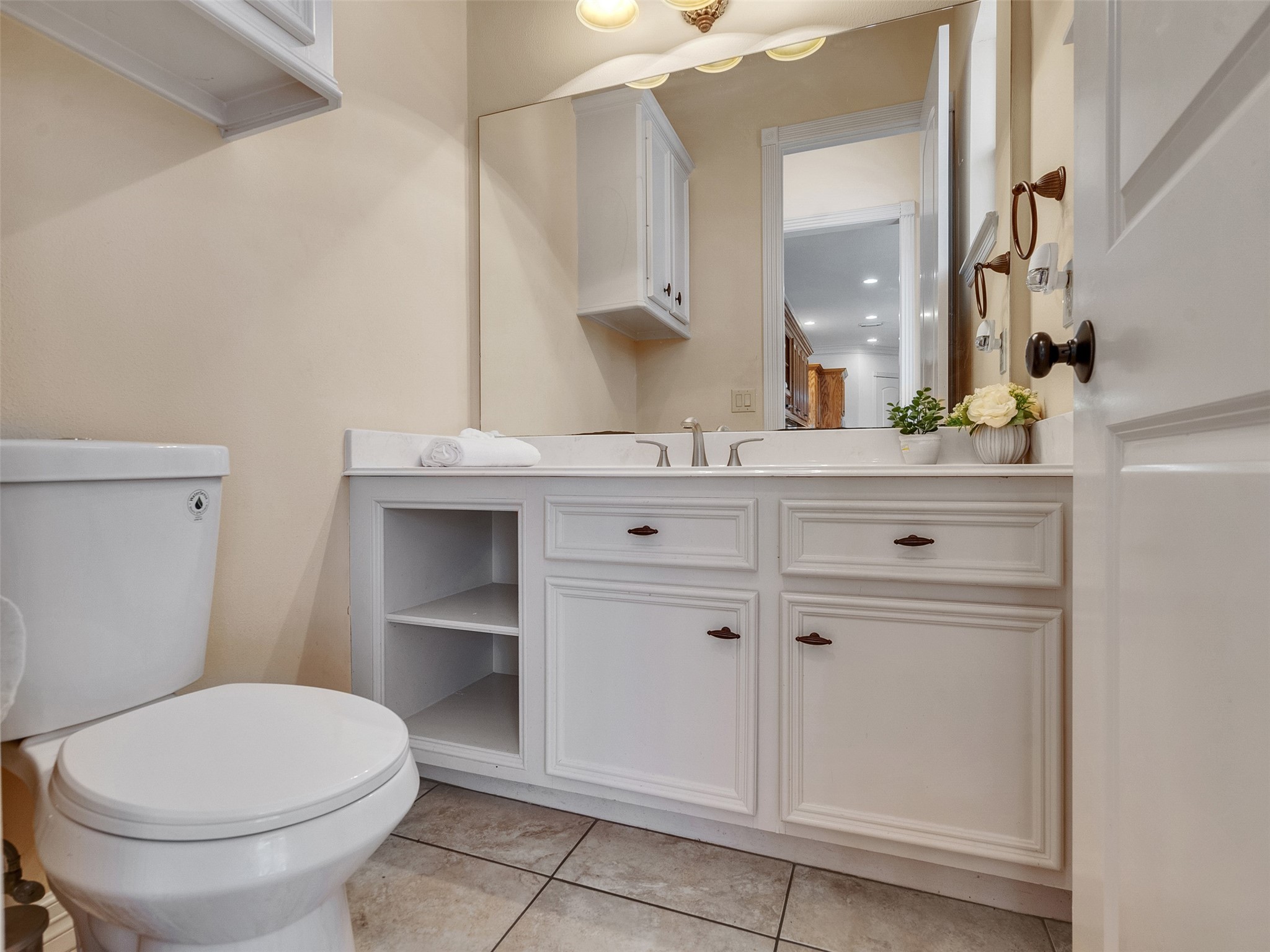 6914 Sandwedge Point Court Spring, TX 77389 - Photo 31 of 50 This is a clean, well-lit bathroom featuring a double sink vanity with ample storage, a large mirror, and a toilet. The neutral tones and tiled floor create a fresh and inviting atmosphere.