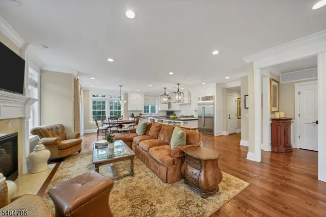 a large kitchen with stainless steel appliances granite countertop a stove and a wooden floors