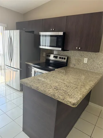 a kitchen with a sink stove and refrigerator