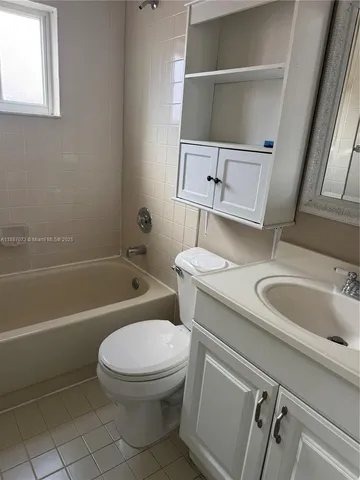 a white toilet sitting next to a bathroom sink and a tub