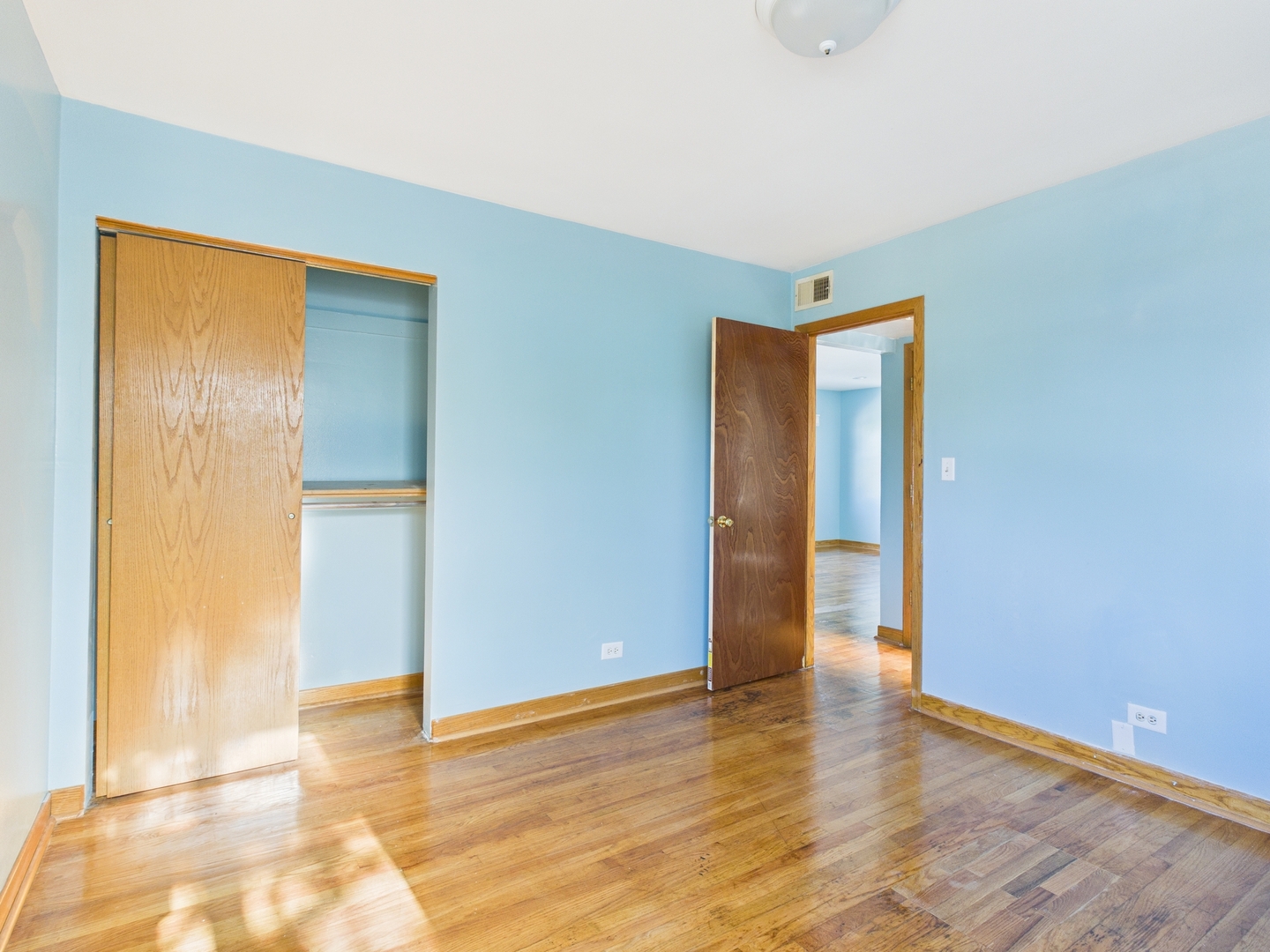 755 Dulles Road, Unit F Des Plaines, IL 60016 - Photo 10 of 12 a view of an empty room with wooden floor and a bathroom