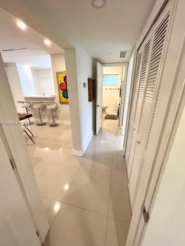 a view of a hallway to a livingroom with furniture