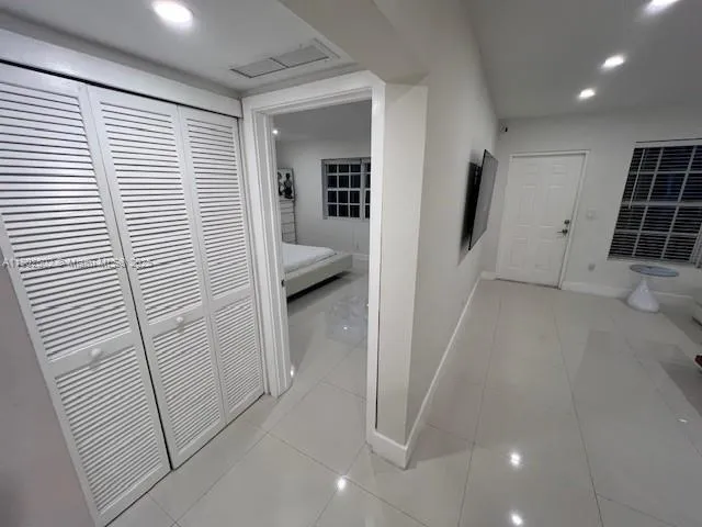 a bedroom with a bed and a refrigerator
