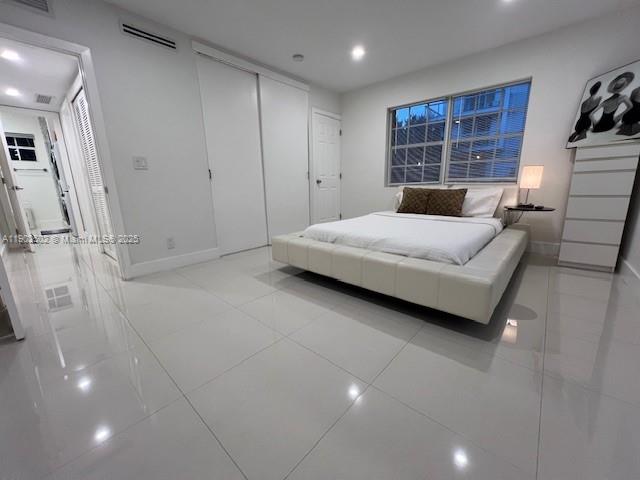 1125 99th Street, Unit 12 Bay Harbor Islands, FL 33154 - Photo 51 of 62 a bedroom with a bed a table and a large mirror