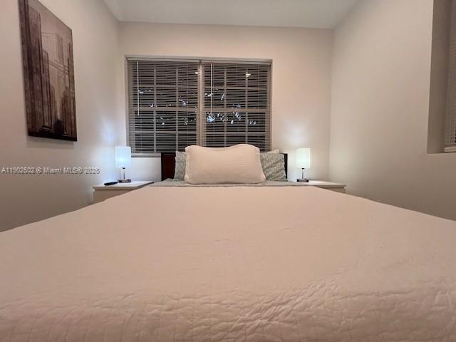 1125 99th Street, Unit 12 Bay Harbor Islands, FL 33154 - Photo 58 of 62 a large bed sitting in a bedroom next to a window