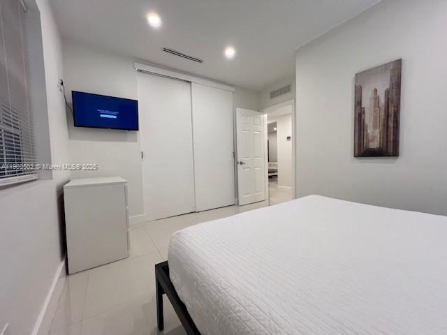 1125 99th Street, Unit 12 Bay Harbor Islands, FL 33154 - Photo 60 of 62 a bedroom with a bed and a refrigerator