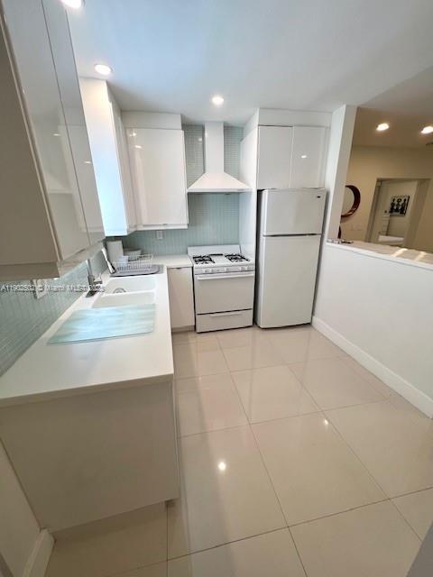 1125 99th Street, Unit 12 Bay Harbor Islands, FL 33154 - Photo 8 of 62 a large white kitchen with a sink a stove a refrigerator and a mirror