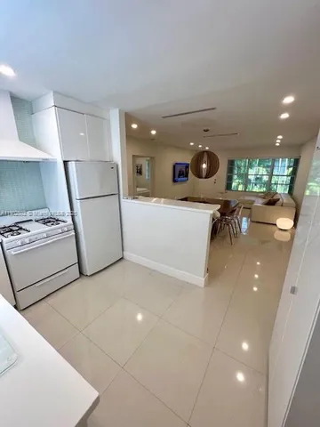 a living room with furniture and a view of kitchen