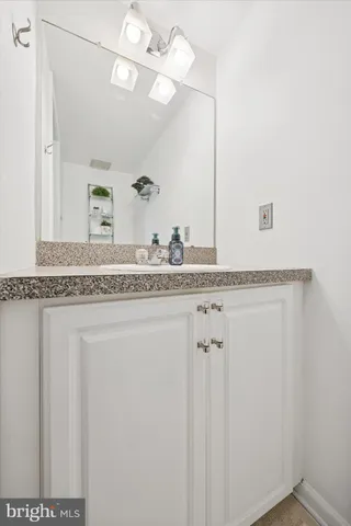 a bathroom with a granite countertop sink and a mirror